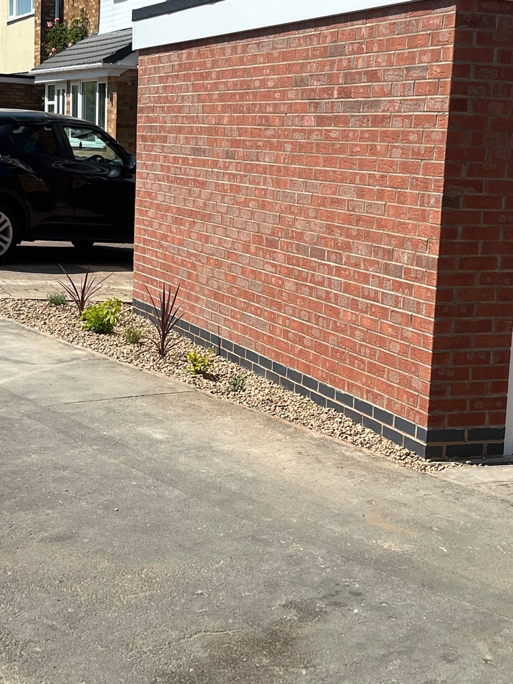 New brick boundary wall with a blue engineering brick course