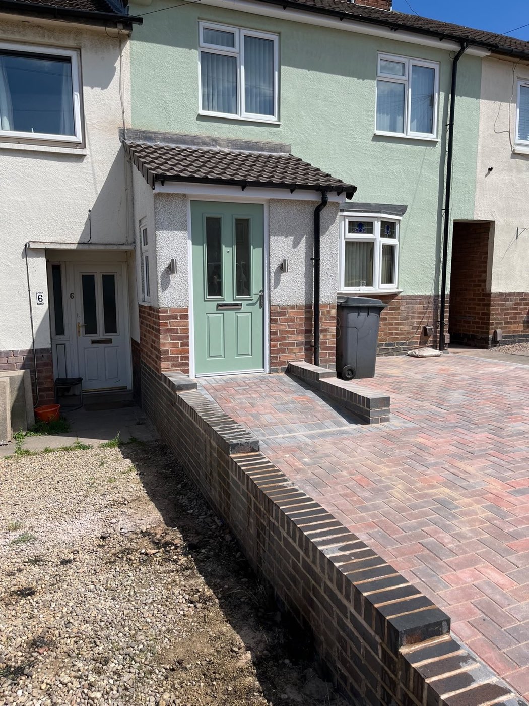 Block paved driveway and brick edging in front of a porch