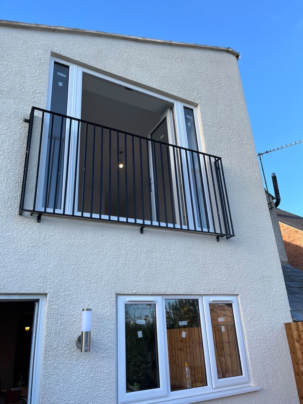 Rendered house elevation with clean glazing and a Juliet balcony